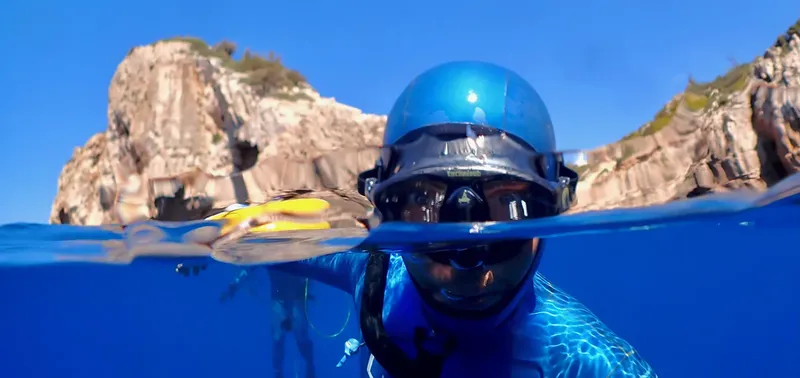 Apnea, nageur en surface regardant vers la camera, ciel bleu