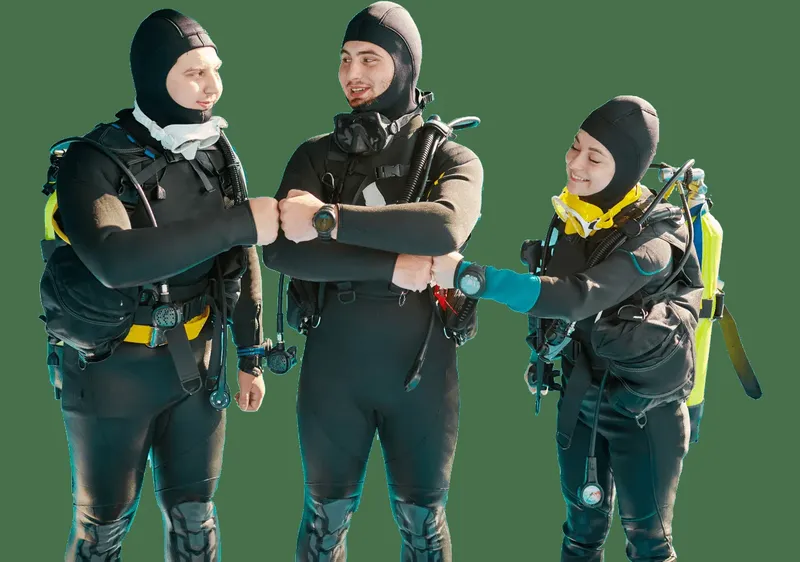 Trois plongeurs en combinaison se serrent la main avec sourire