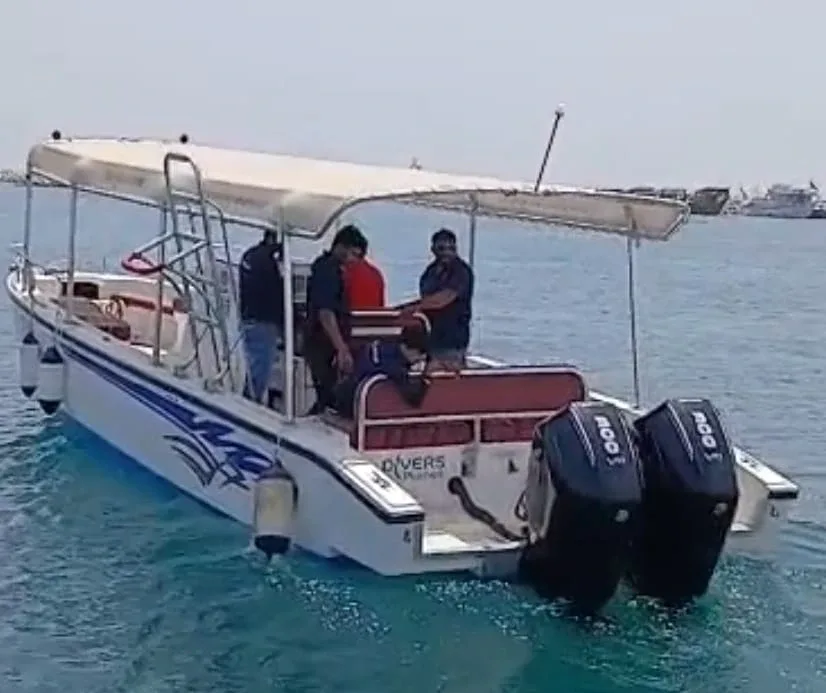 Bateau de plongée blanc avec passagers naviguant sur une mer calme