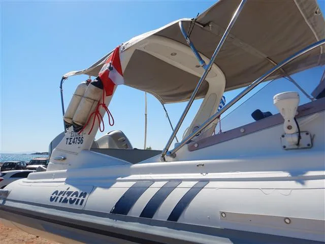Bateau de plongée blanc et bleu amarré au soleil avec bouteilles