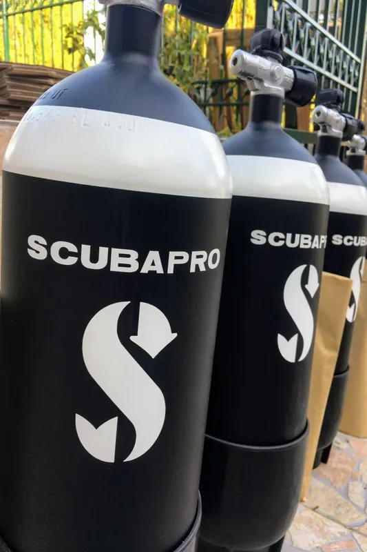 Bouteilles de plongée noires avec logo Scubapro alignées à l'extérieur