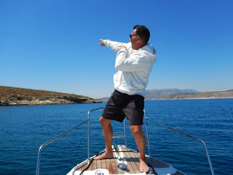Homme pointant au loin depuis le pont d'un bateau en mer