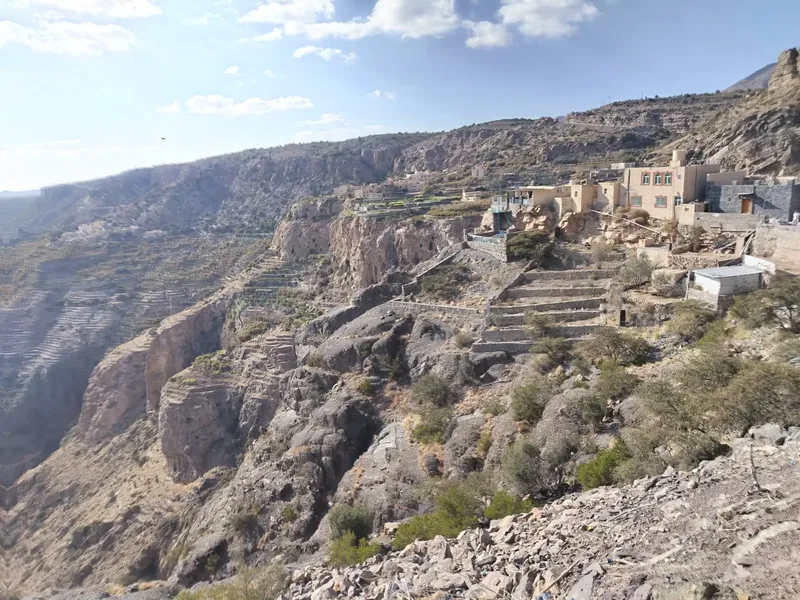 Paysage montagneux aride avec bâtiments au bord d'une falaise abrupte
