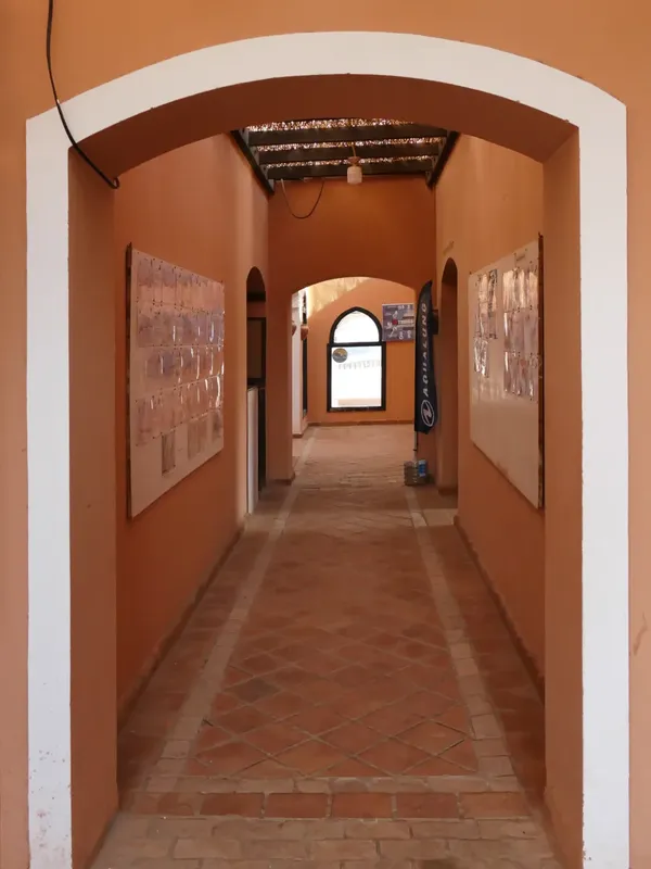 Couloir intérieur d'un bâtiment avec des murs orange et des carreaux