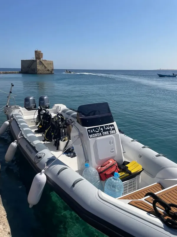 Bateau semi-rigide amarré au port avec équipement de plongée à bord