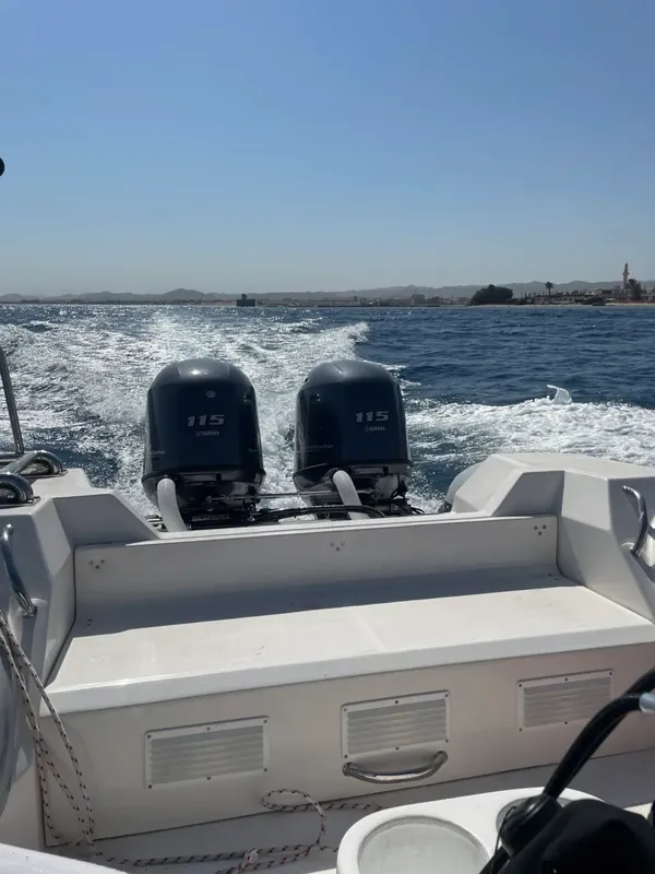 Bateau semi-rigide blanc naviguant sur une mer bleue sous un ciel clair
