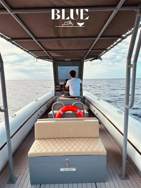 Homme conduisant un bateau pneumatique sur une mer calme et bleue