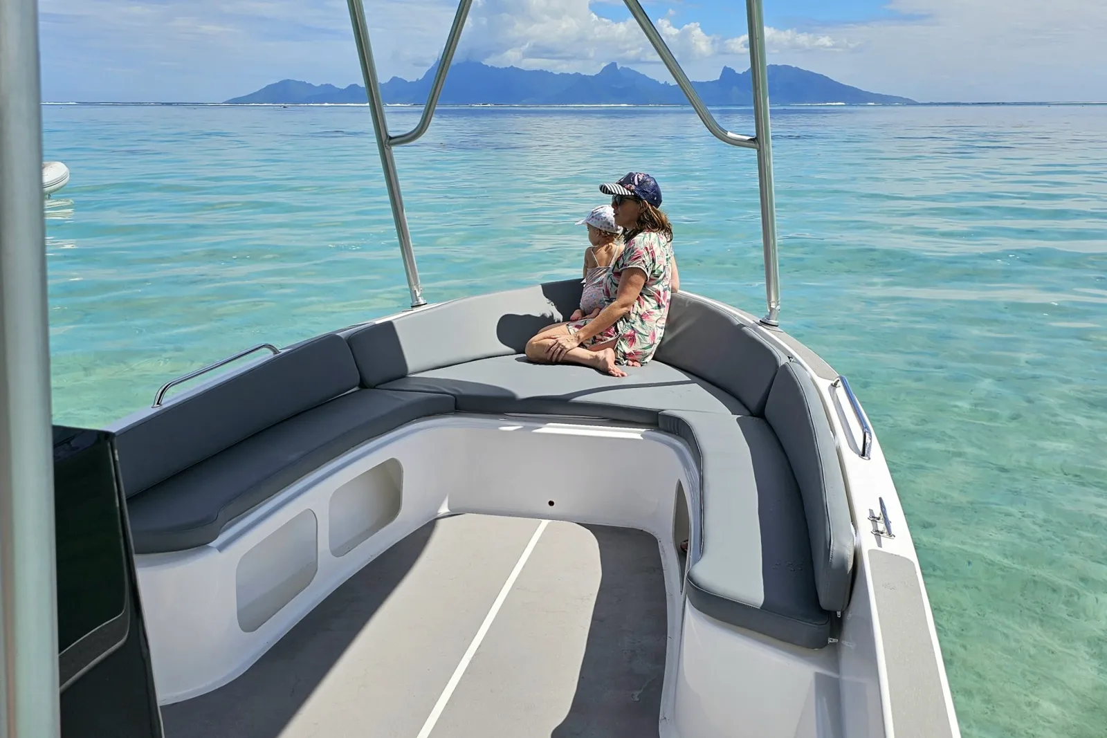 Deux personnes assises sur un bateau en mer turquoise