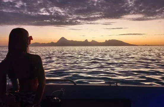 Silhouette d'une personne regardant le coucher de soleil en mer