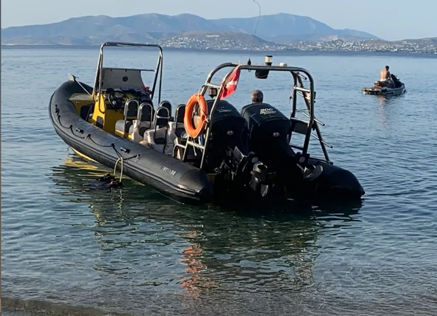 Bateau semi-rigide jaune et noir sur l'eau avec des passagers