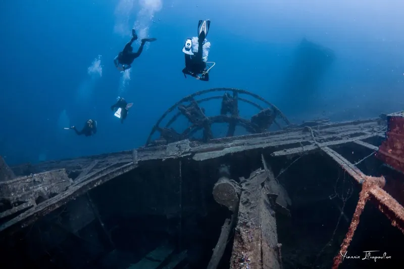 Plongeurs explorant l'épave d'un navire rouillé en milieu marin