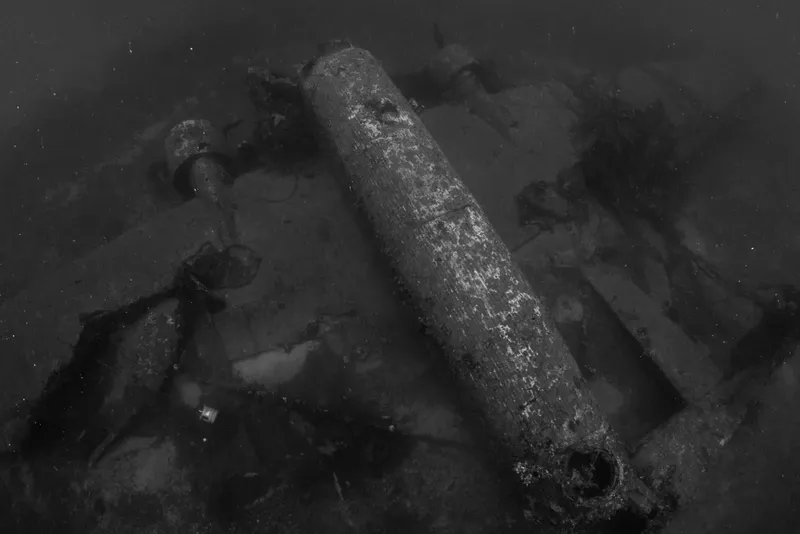 Épave sombre et partiellement recouverte d'algues sous l'eau