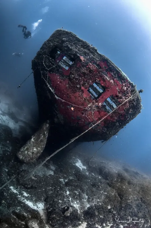Epave de bateau rouillée, plongée sous-marine, un plongeur explore le site