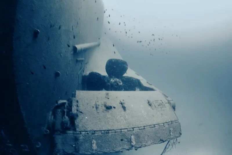 Epave sous-marine recouverte de sédiments et de petits poissons