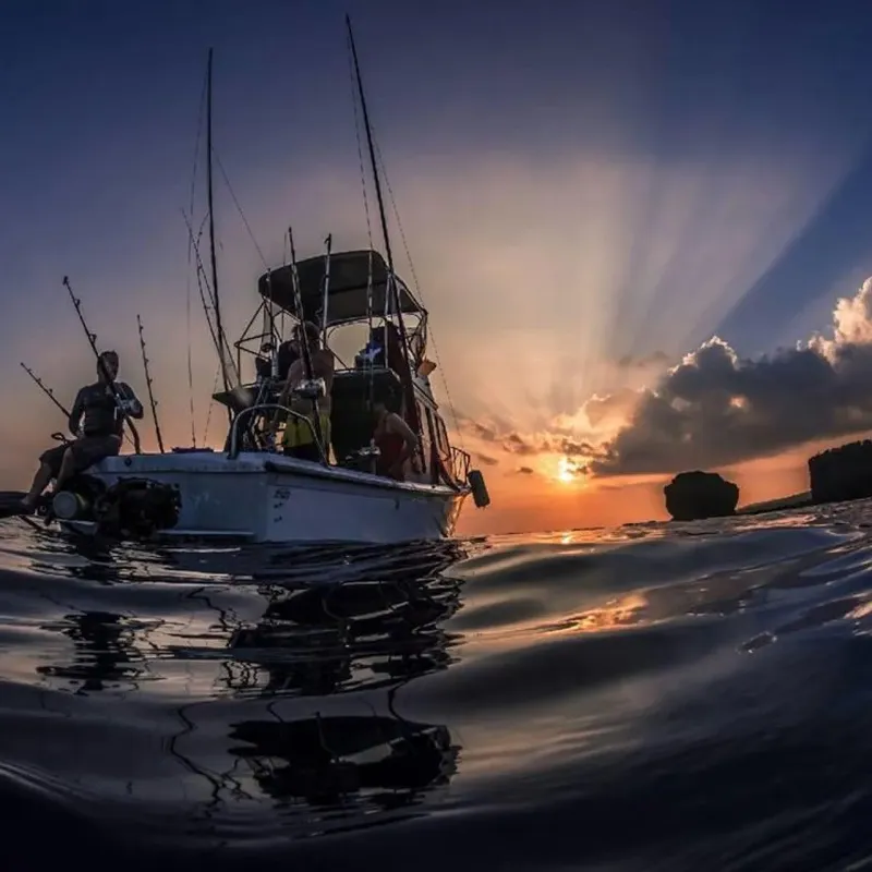 Plongée : personnes à bord d'un bateau au coucher du soleil