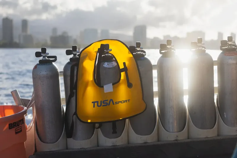 Bouteilles de plongée et masque jaune TUSA sur un bateau