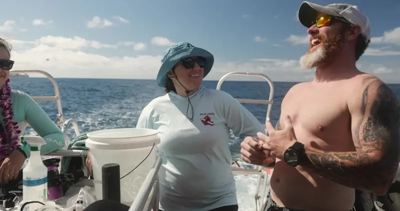 Plongeurs souriants sur un bateau, préparant une sortie en mer