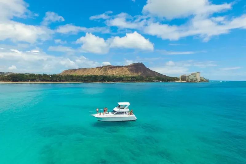 Bateau de plaisance naviguant sur une eau turquoise ensoleillée