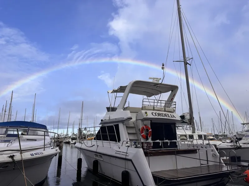 Bateau de plaisance amarré dans un port avec un arc-en-ciel en arrière-plan