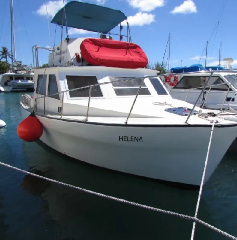Bateau de plongée blanc amarré dans un port ensoleillé