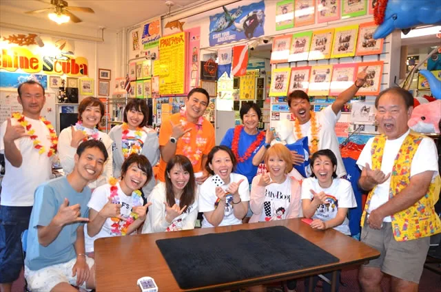 Groupe de personnes souriantes dans un magasin de plongée avec décorations