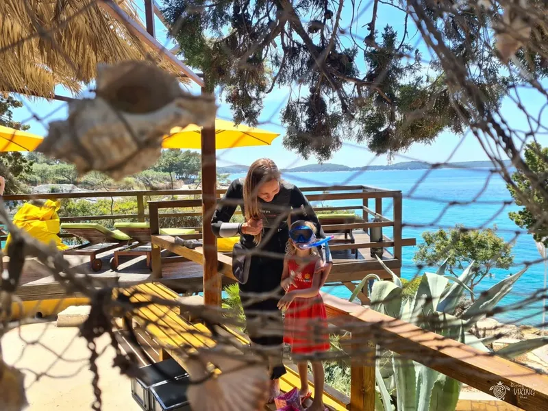 Deux personnes près d'une terrasse en bois avec vue sur la mer