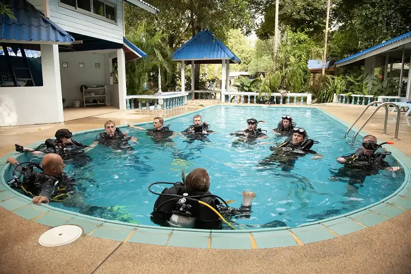 Groupe de plongeurs en formation dans une piscine avec équipement