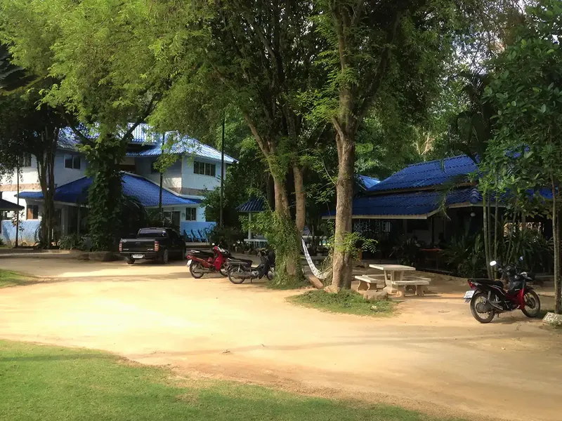 Batiments du centre de plongee, parking, motos et vegetation tropicale