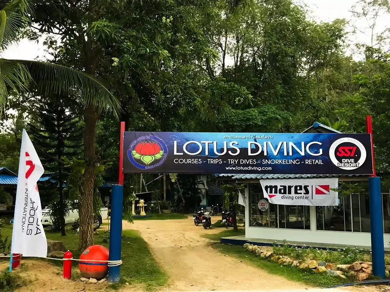 Entrée d'un centre de plongée avec enseigne et drapeau Lotus Diving