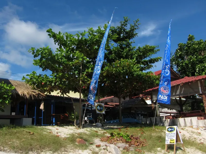 Devanture d'un centre de plongée avec des drapeaux PADI et signalétique