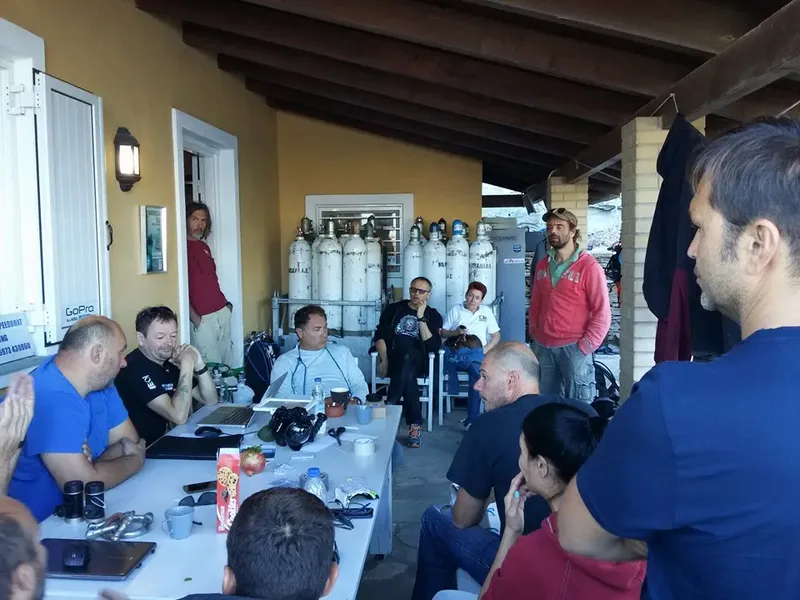 Groupe de personnes discutant près de bouteilles de plongée et d'un instructeur