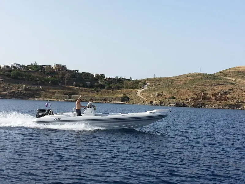 Un homme conduit un semi-rigide sur une mer bleue et calme