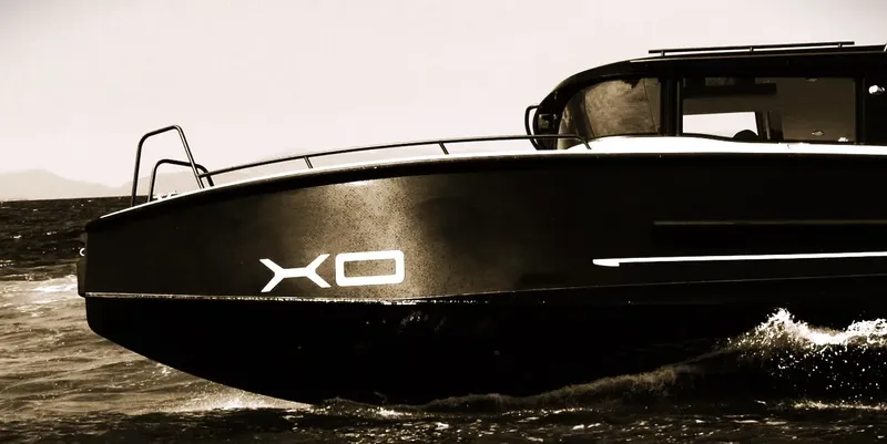 Bateau de plongée noir naviguant sur une mer calme et agitée