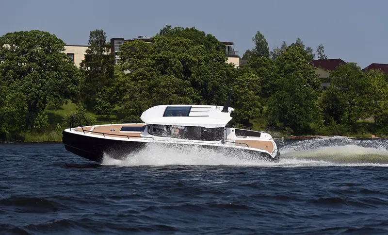 Bateau rapide naviguant sur une eau calme avec végétation au bord
