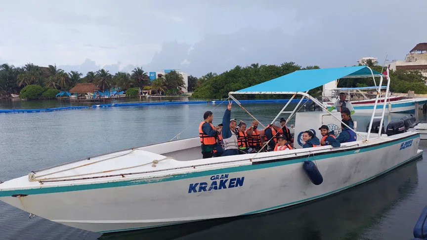 Groupe de personnes à bord d'un bateau de plongée bleu et blanc