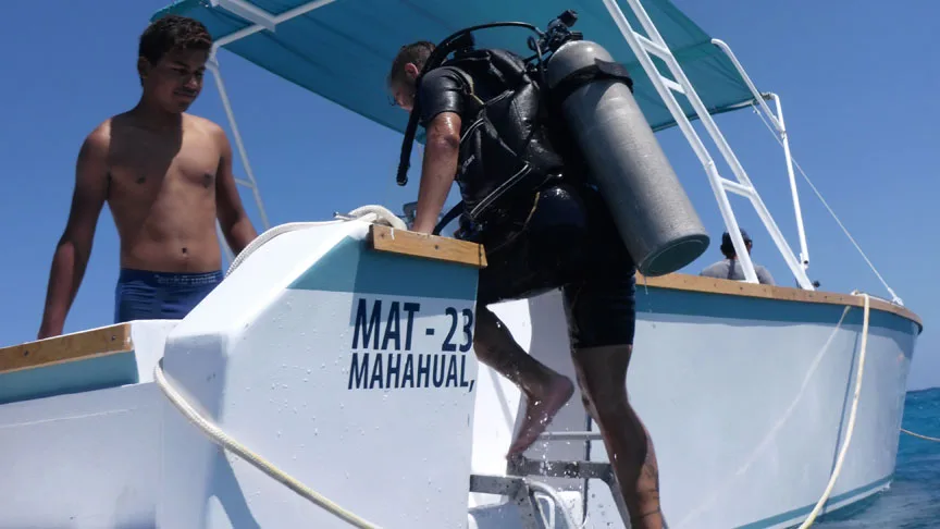 Deux plongeurs se préparent à entrer dans un bateau de plongée