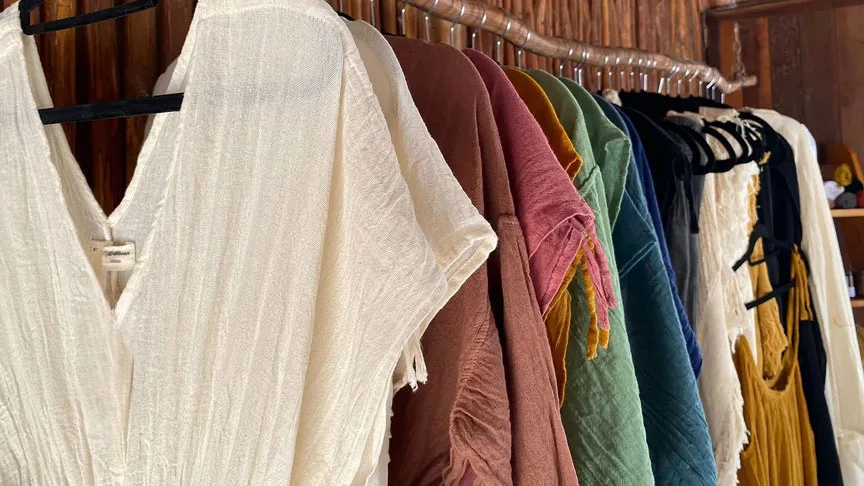 Rangée de vêtements légers de différentes couleurs suspendus sur cintres