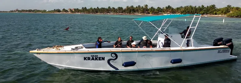 Bateau de plongée avec passagers naviguant sur une eau turquoise calme
