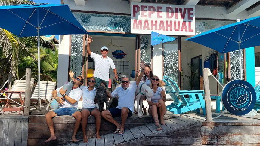 Equipe souriante devant le centre de plongée, ambiance conviviale et ensoleillée
