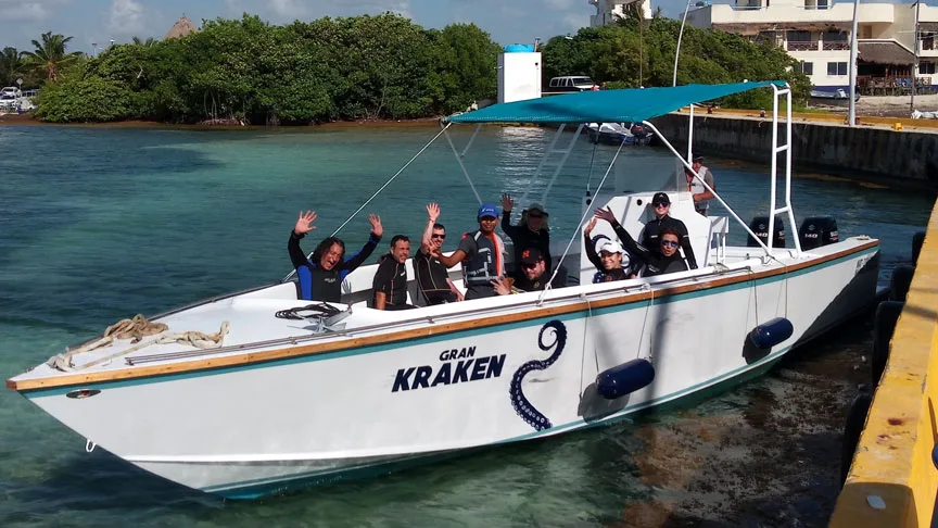 Groupe de personnes souriantes sur un bateau de plongée amarré