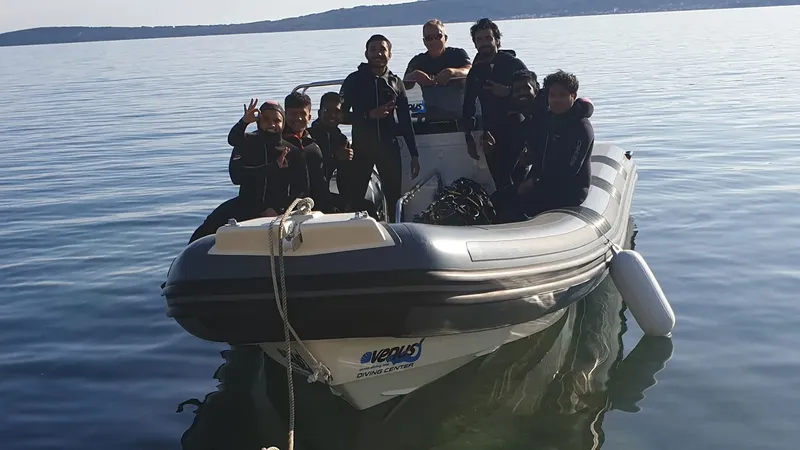 Groupe de plongeurs souriants à bord d'un bateau semi-rigide en mer