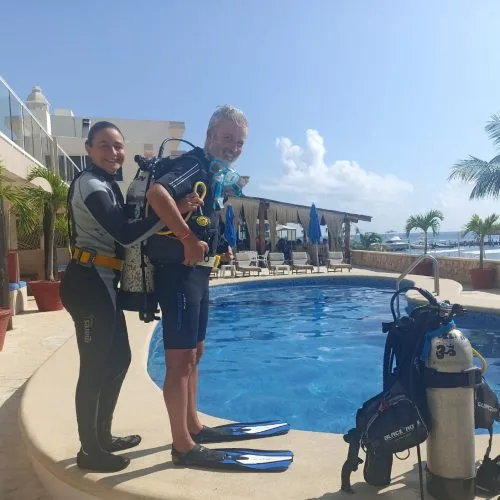 Deux plongeurs équipés près d'une piscine ensoleillée préparation plongée