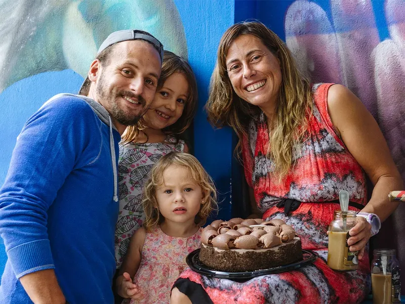 Famille souriante posant avec un gâteau décoré et des boissons