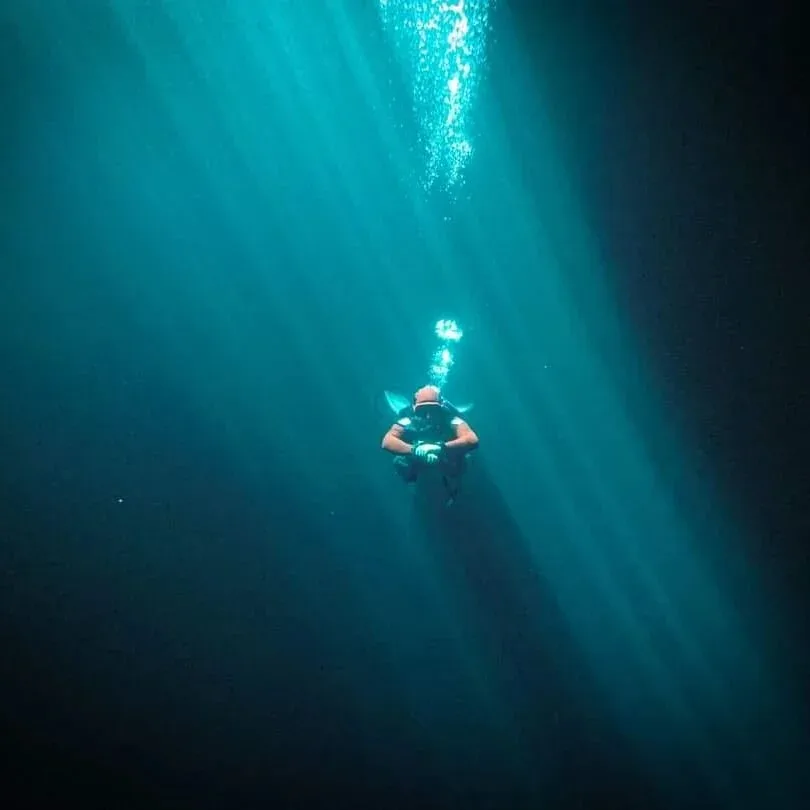 Plongeur solitaire évoluant dans une eau turquoise et lumineuse