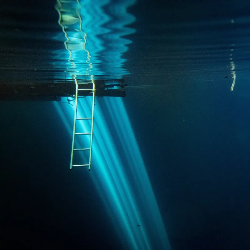 Échelle de ponton sous la surface de l'eau, rayons lumineux