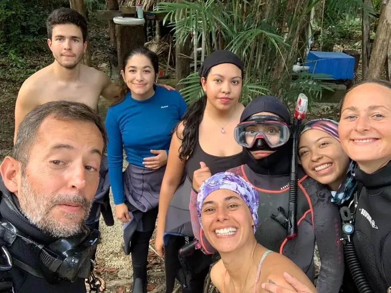 Groupe de personnes souriantes, équipement de plongée, ambiance décontractée