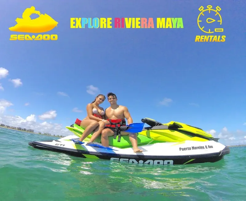 Deux personnes souriantes sur un jet ski bleu en mer turquoise