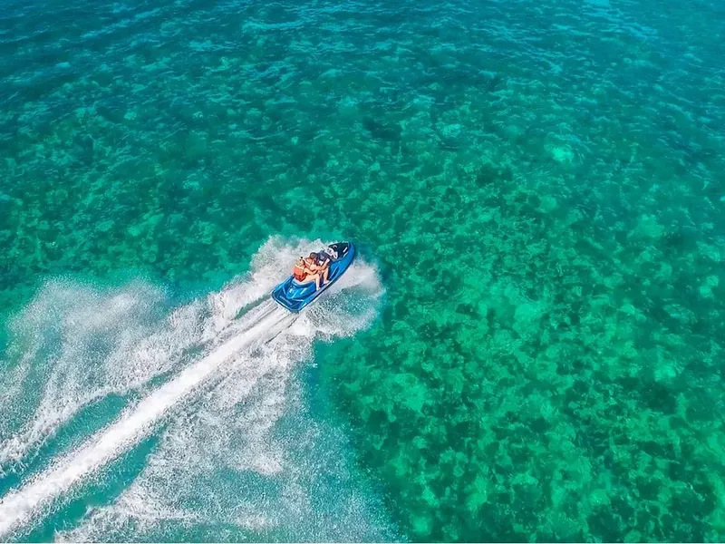 Vue aérienne d'un bateau rapide naviguant sur une eau turquoise claire