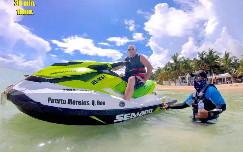 Deux personnes sur un jet ski sur une plage ensoleillée