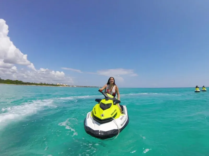 Jeune femme conduisant un jet ski sur une mer turquoise
